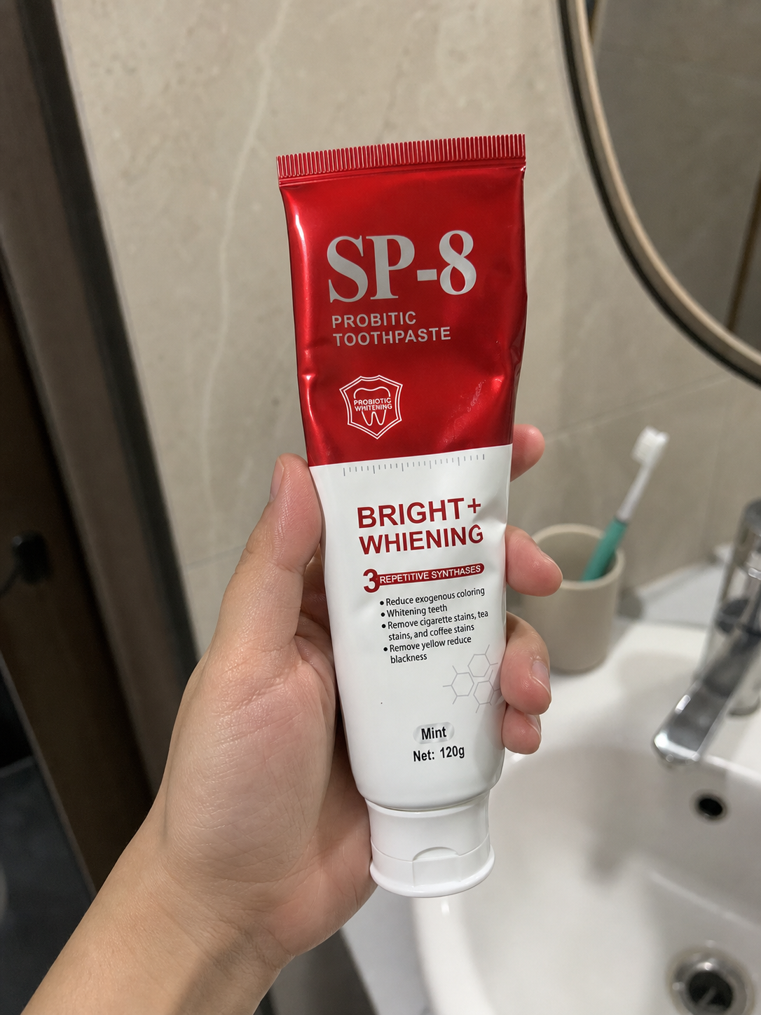 Demo customer holding a partially used SP-8 toothpaste tube