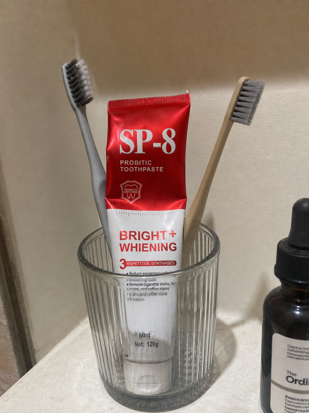 Demo customer photo of a used SP-8 toothpaste tube stored with toothbrushes
