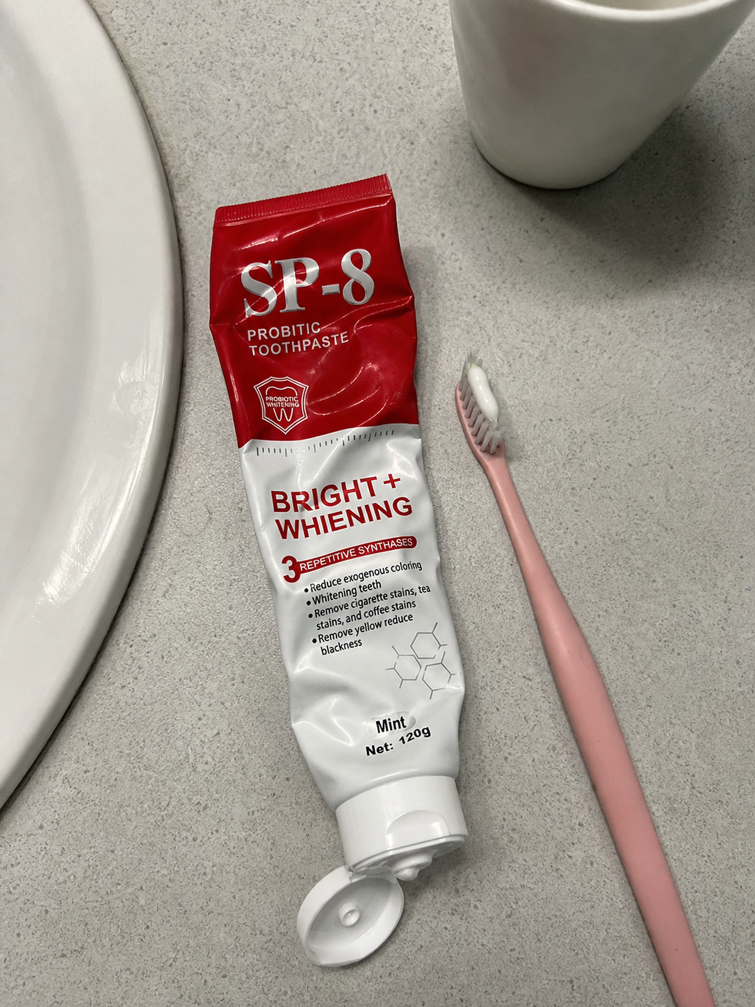 Demo customer photo of a well-used SP-8 toothpaste tube with a toothbrush