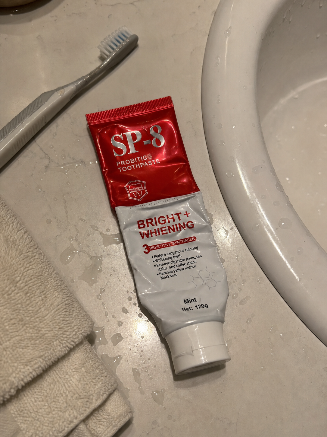 Demo customer photo of a well-used SP-8 toothpaste tube beside a wet sink