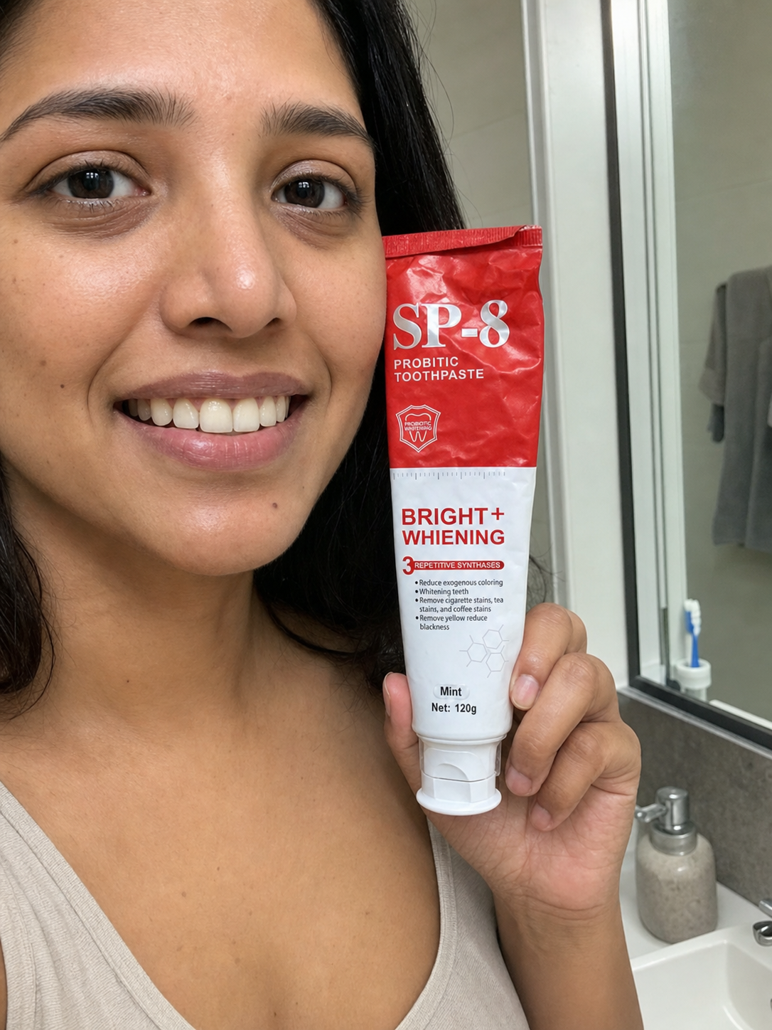 Teaching-demo customer photo of a South Asian woman smiling while holding SP-8 toothpaste